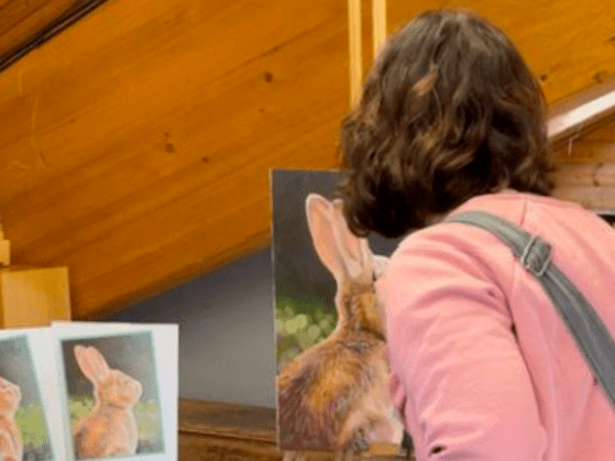 Molly painting at an easel.